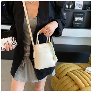 Chic cream mini crossbody bag with tulip charm and elegant top handles on model