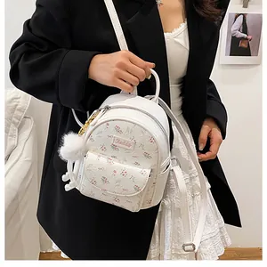 Detail of mini floral backpack with Kaddy branding, bow prints and white pompom charm