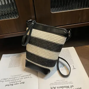 Mini borsa a secchiello minimalista a righe bianche e nere con tracolla su rivista
