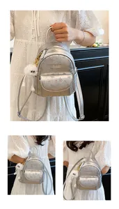 Detail of silver mini backpack with floral patterns and plush charm on black background