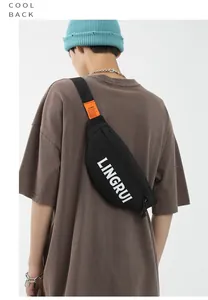 Rear view of a black waterproof oxford chest bag with white text on a male model