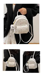 Detail of white PU leather mini backpack with purple floral pattern and plush charm accessory