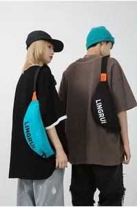 Detail of blue and black waterproof oxford fabric crossbody bags with orange accent tags