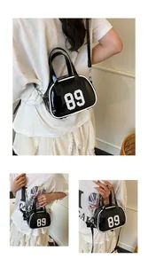 Detail view of glossy black patent leather bowling bag with white 89 print and contrast stitching