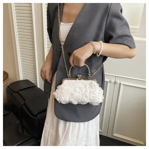 Detail of white 3D floral petals and pearls on evening bag with gold metal frame