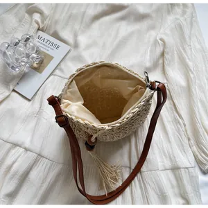Detail view of woven straw bag with metal zipper closure and soft beige fabric lining