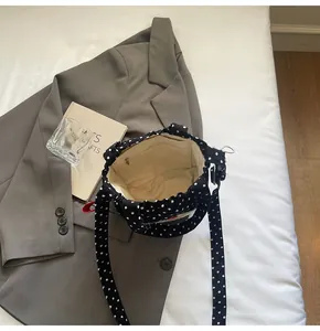 Vue intérieure du sac en toile à pois noirs avec doublure beige et poche zippée interne