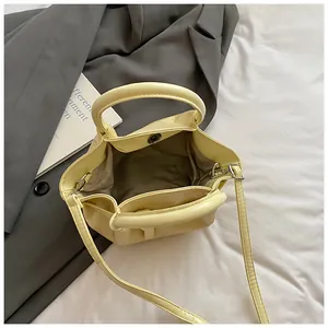 Cream yellow crossbody bucket bag with interior compartment and magnetic clasp