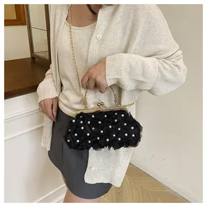 Detail of black 3D rose petal evening bag with pearl accents and gold metal chain