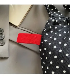 Détail du sac en tissu à pois avec ruban rayé rouge et surface à texture côtelée