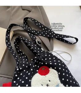 Détail du sac en toile noir à pois avec broderie et bandoulière réglable pratique