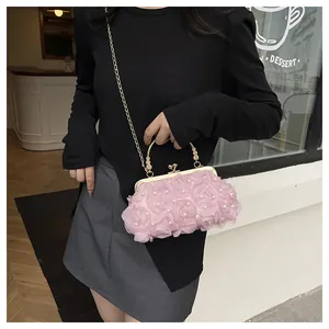 Detail of pink mesh 3D roses on party clutch bag with pearl accents and gold handle