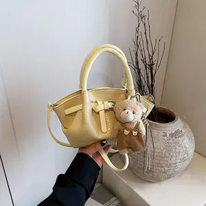 Chic yellow crocodile embossed handbag with adjustable strap and cute bear charm