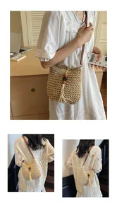 Detail of woven straw crossbody bag featuring cream texture, tassels and wooden beads