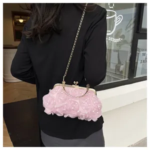 Detail of pink floral evening bag with pearls and gold chain on model's back