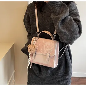 Pink glossy backpack with sparkling rhinestones and a cute plush bear charm detail