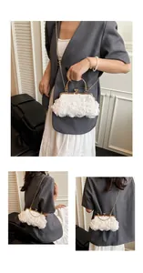 Close-up of white floral evening bag with pearl accents and gold metal chain strap