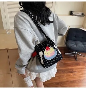 Détail de la broderie de glace sur sac seau en toile noire à pois blancs élégant