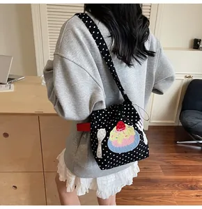 Détail du sac en toile à pois noirs avec broderie de dessert fraise et cordon de serrage