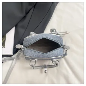 Internal view of mini light blue denim bag with zipper closure and grey fabric lining