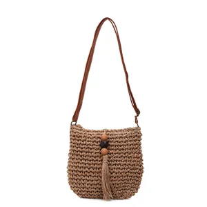 Fashionable woven crossbody bag with brown leather strap and decorative fringe tassels
