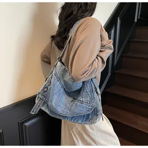 Dettaglio della borsa tote in denim blu lavato con fibbie e design multitasche