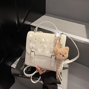 White PU leather school bag with rhinestones, double bows, and a plush bear pendant
