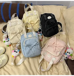Detailed view of canvas handbags with bow knots and cute plush pendants in various colors