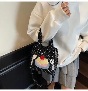 Détail du sac en toile à pois noirs avec broderies de desserts et motifs de cuillères