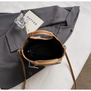 Overhead view of a canvas bucket bag showing a spacious black interior with zipper pocket