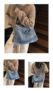 Dettaglio della borsa in denim vintage con rivetti metallici e trama in tessuto lavato