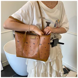Détail d'un sac cabas marron avec motifs d'ours et de nœuds et texture grainée