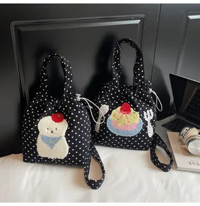 Détail de sacs à pois avec broderie d'animaux et accessoires technologiques de bureau
