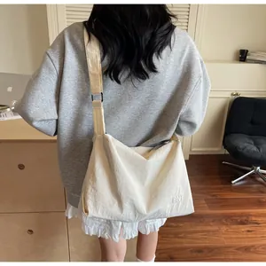 Detail of cream white large crossbody bag with BNT embroidery and wide shoulder strap