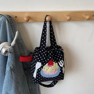 Sac bandoulière minimaliste en toile brodée avec motif fraise sur crochet mural