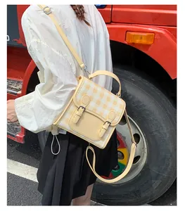 Detail of yellow and beige checkered retro crossbody bag with adjustable shoulder strap