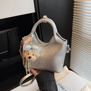 Silberne Handtasche mit Metallic-Finish, Lederstruktur und Bärenanhänger für Damen