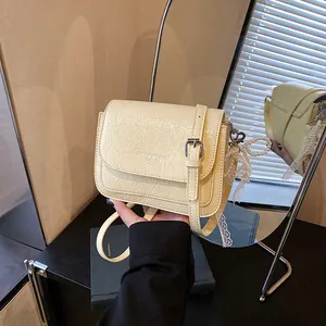 Minimalist cream crossbody bag with pleated texture and pearl lace bow charm