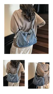 Detail view of a large vintage denim tote bag with visible white woven label and stitching