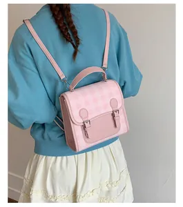 Pink gingham mini backpack on model back showing compact size and retro buckle details