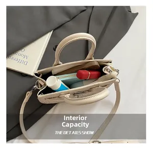 Internal capacity of off-white saddle bag with studs showing phone and cosmetics