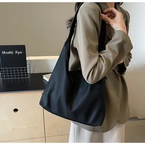 Detailaufnahme einer schwarzen Shopper-Tasche aus Lederimitat mit breitem Gurt