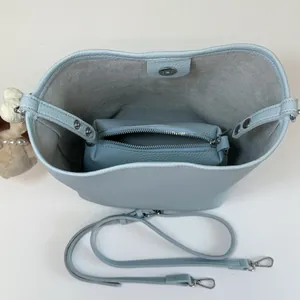 Top view of light blue bucket bag with inner pouch, litchi grain texture and plush charm