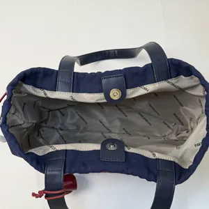 Navy canvas tote bag with leather handles and spacious logo-printed interior lining