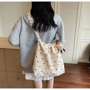 Rear view of a floral mesh drawstring bag with red bows and a plush pendant accessory