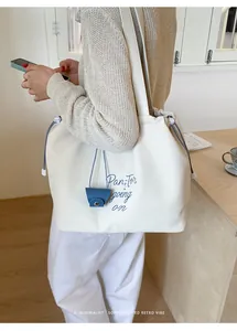 Detail of canvas tote bag with blue drawstring closure and small accessory pouch