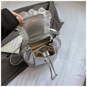 Mini silver backpack with lace trim and metallic finish shown from a top-down view