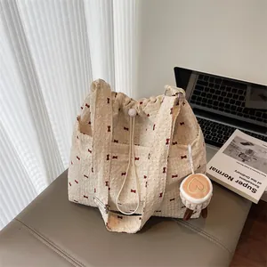 Mesh drawstring shoulder bag with red bow pattern and latte plush charm for women