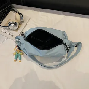 Light blue canvas crossbody bag with large capacity and cartoon doll pendant accessory