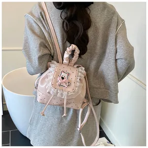 Pink mini backpack with polka dots, lace trim, and cute cartoon patch in a lifestyle view